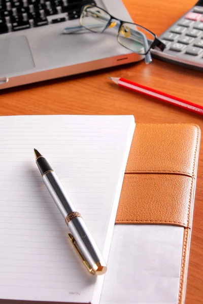 Ofis işyeri dizüstü bilgisayar ve tahta masalarda akıllı telefon