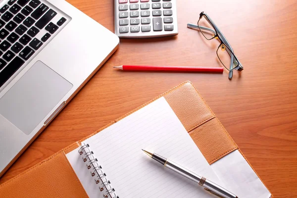 Ofis işyeri dizüstü bilgisayar ve tahta masalarda akıllı telefon