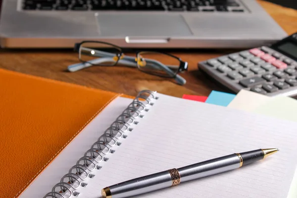 Ofis işyeri dizüstü bilgisayar ve tahta masalarda akıllı telefon