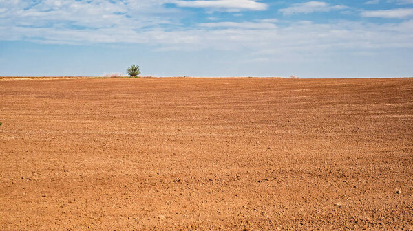 Ploughed agricultural land with a cloudy sky above