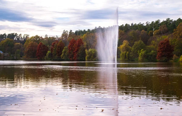 Fuente rociando agua sobre el fondo del bosque de otoño — Foto de Stock
