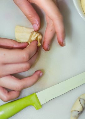 Bir kızın elleri hamuru kurabiyelere hazırlar.