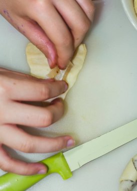 Bir kızın elleri hamuru kurabiyelere hazırlar.