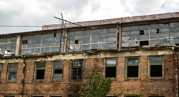 Abandoned factory warehouse with broken windows and covered in g — Stock Photo, Image