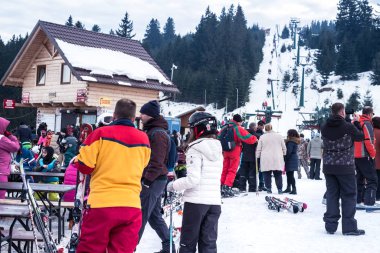 Bir dağ yamacında bir sürü insan kayak yapıyor.