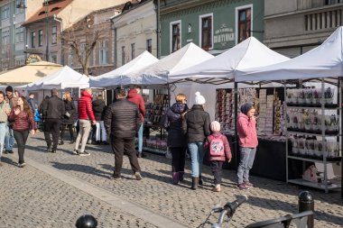 Sibiu şehri, Romanya - 29 Şubat 2020. İnsanlar Sibiu kentindeki Balcescu caddesindeki büyük martenitsa pazarında Martisor 'e bakıyorlar. Baharın sembolleri, Romence 