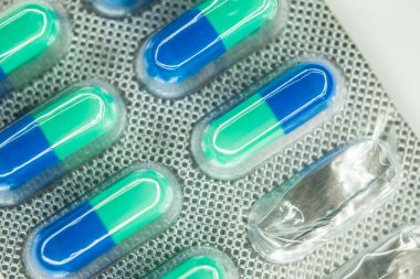 Su toplayan yeşil haplarla birlikte ilaç mavisi.