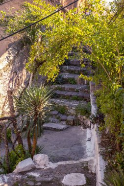 Atina, Yunanistan - 18 Şubat 2020. Atina 'nın geleneksel bir mahallesi olan Plaka' nın dar sokaklarından Akropolis, Yunanistan 'ın yamaçlarında yer alan mimari ayrıntılar