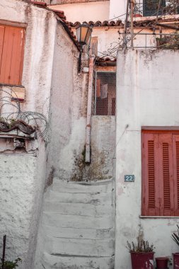 Atina, Yunanistan - 18 Şubat 2020. Atina 'nın geleneksel bir mahallesi olan Plaka' nın dar sokaklarından Akropolis, Yunanistan 'ın yamaçlarında yer alan mimari ayrıntılar