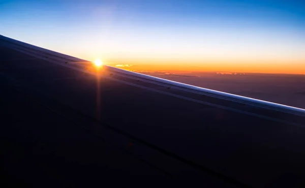日出时分 轮廓飞机在云彩上展翅 — 图库照片