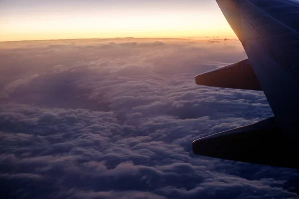 日出时分 轮廓飞机在云彩上展翅 — 图库照片