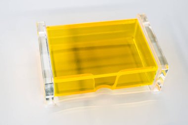 Beyaz arkaplanda saydam sarı plastik kutu