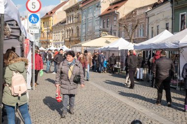 Sibiu şehri, Romanya - 29 Şubat 2020. İnsanlar Sibiu kentindeki Balcescu caddesindeki büyük martenitsa pazarında Martisor 'e bakıyorlar. Baharın sembolleri, Romence 