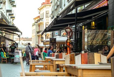 Bükreş kenti, ROMANIA - 19 Eylül 2017: Bükreş 'in en işlek caddelerinden biri olan Lipscani Caddesi şehir merkezindeki Açık Restoran Cafe' de Turistler Ziyaret Ediyor ve Öğle Yemeği Yiyor.