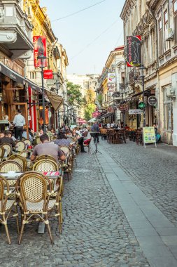 Bükreş kenti, ROMANIA - 19 Eylül 2017: Bükreş 'in en işlek caddelerinden biri olan Lipscani Caddesi şehir merkezindeki Açık Restoran Cafe' de Turistler Ziyaret Ediyor ve Öğle Yemeği Yiyor.
