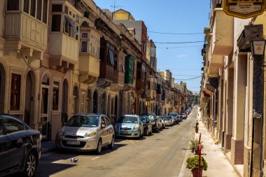 Albert City, Malta - 17 Temmuz 2019. Malta 'nın Albert şehrinde geleneksel Malta mimarisi, geleneksel balkonları ve tarihi Malta şehrinde eski binaları olan cadde.