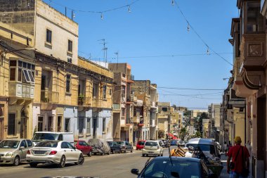 Albert City, Malta - 17 Temmuz 2019. Malta 'nın Albert şehrinde geleneksel Malta mimarisi, geleneksel balkonları ve tarihi Malta şehrinde eski binaları olan cadde.