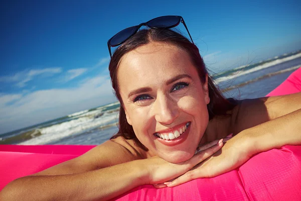 Primer plano de la mujer hermosa eufórica y sonriente que está acostada en p — Foto de Stock