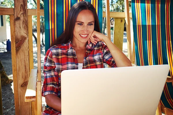 Lachende vrouw in casual outfit kijken naar het scherm van de laptop w — Stockfoto