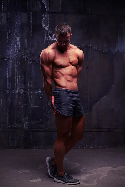 Симпатичный голый мужчина-модель фитнеса позирует в спортивных шортах — стоковое фото