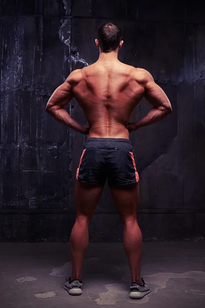 Pohled zezadu záběr svalnatý mladík v sportovní šortky — Stock fotografie