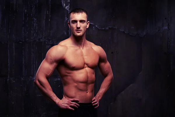 Bare-chested handsome man with reliefed muscles standing half-tu — Stock Photo, Image