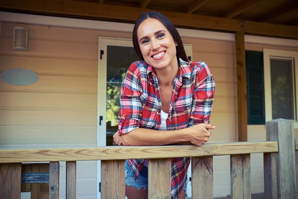 Nahaufnahme einer charmanten Frau, die auf der Veranda eines Erholungshauses steht — Stockfoto