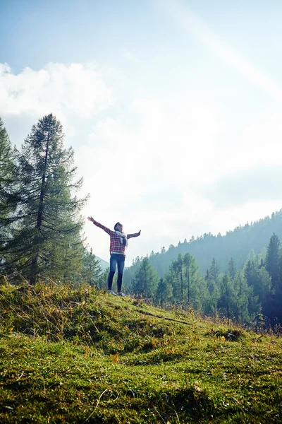 Frau breitet Hände aus und spürt die Freiheit auf dem Berg — Stockfoto