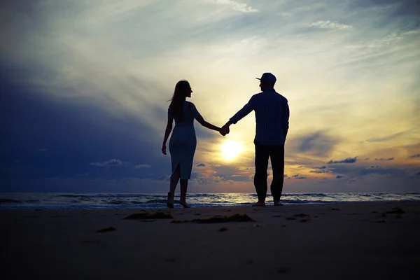 Silhouette of fascinating lovely couple holding hands at the uns — Stock Photo, Image