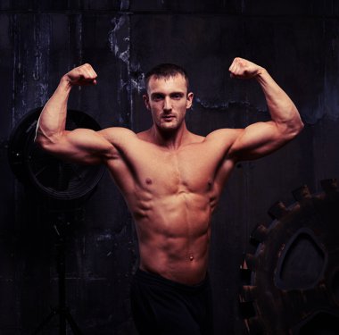 Kaba gri wal karşı tonda eğitimli gövdeli genç vücut geliştirmeci