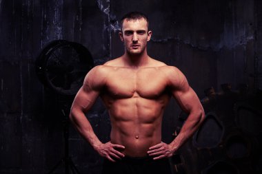 Kalçalarına kaslı seksi gömleksiz adam ile ayakta eller