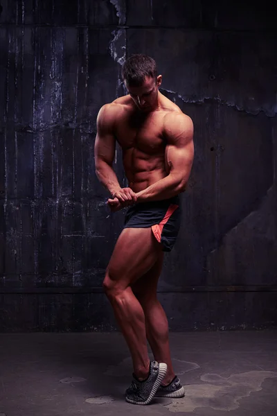 Ισχυρό άνδρα του αθλητισμού σορτς με γυμνό τον κορμό κάμψη τους μυς — Φωτογραφία Αρχείου