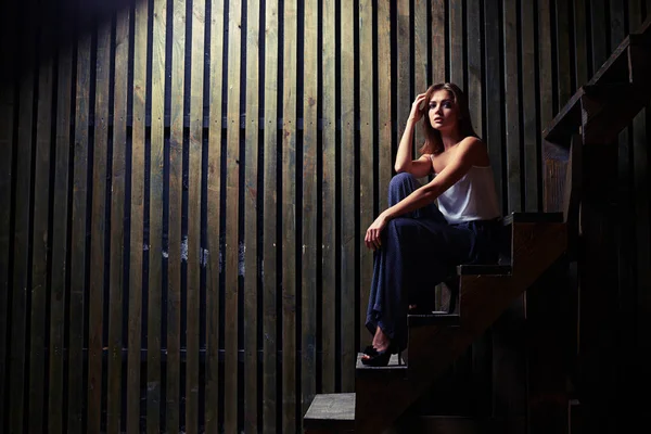 Hassas erkek bir el ızg eğilerek ahşap merdivenlerde oturan