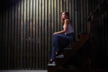 Rahat genç bayan merdivenlerde w bakarken oturuyor