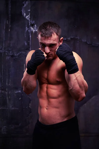 Strong muscular boxer is ready to fight posing over black backgr — Stock Photo, Image
