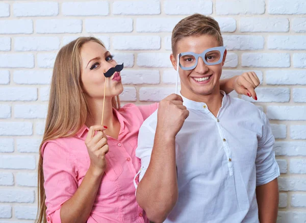 Belle jeune couple tient des bâtons, regardant la caméra et — Photo