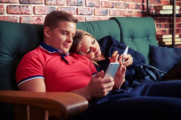 Modernes Paar nutzt Handy im Sitzen und ignoriert einander — Stockfoto