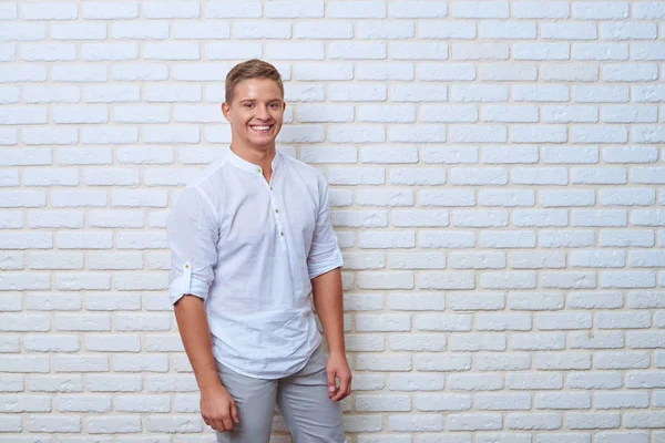 Portre rahat yakışıklı genç adamın üzerinde beyaz tuğla duvar bac — Stok fotoğraf