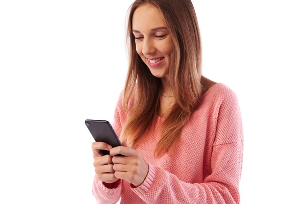 Módní vypadající dívka textilie na smartphone stojící zapnout vedlejší — Stock fotografie