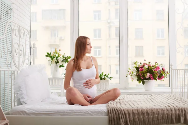 Átgondolt terhes nő néz körül ülve a — Stock Fotó