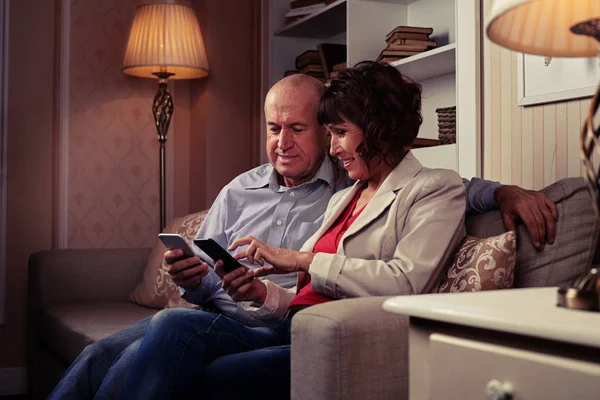 Genial casal olhando para os telefones — Fotografia de Stock