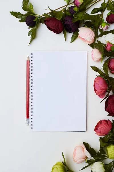 Notebook omringd door de pioenrozen — Stockfoto