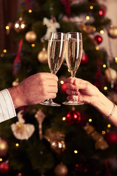 Twee overhandigt rammelende champagne glazen wazig Nieuwjaar backg — Stockfoto