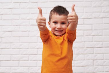 Neşeli bir çocuk onun başparmak-up gösterilen