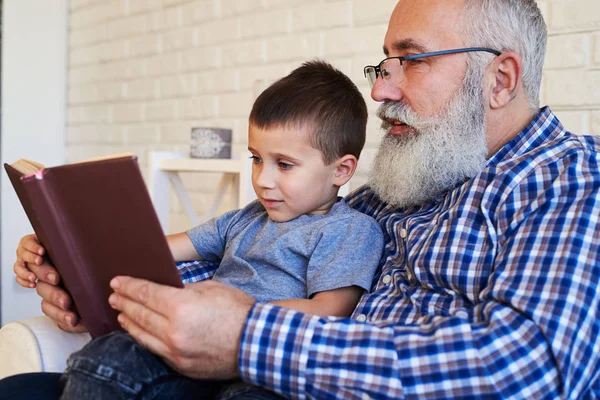 Старший дедушка и его внук внимательно читают инт — стоковое фото