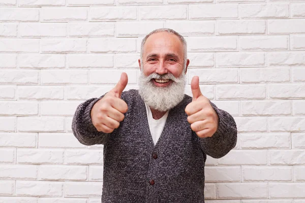 Geniş gülümsüyor ve başparmak-up gösterilen neşeli adam