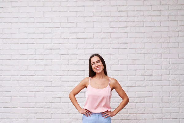 Pleasant smiling lady with two hands on hips posing over white b — Stock Photo, Image