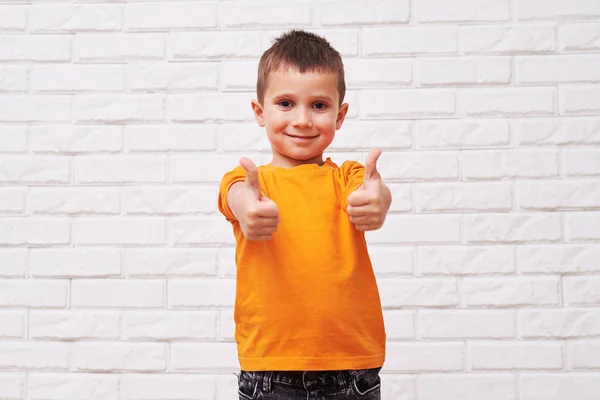 Zubatý usmívající se pohledný chlapec drží palce up — Stock fotografie