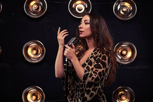 Magnífica morena em um vestido de leopardo chiffon cantando em um sil — Fotografia de Stock