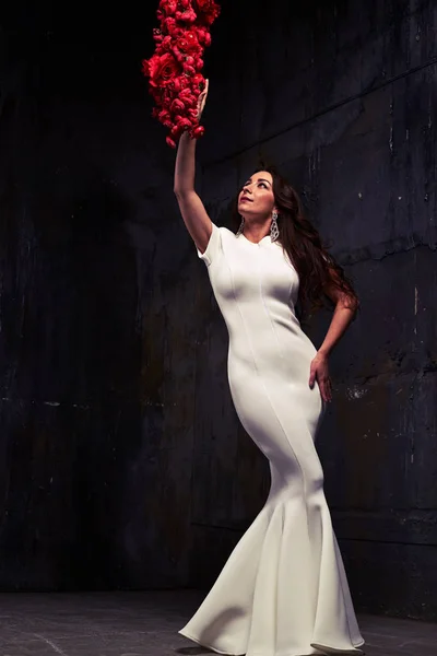 Low angle shot of stunning woman in white evening dress touching